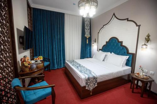 una camera d'albergo con letto e sedia di The Shahar a Tashkent