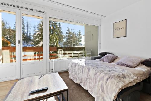 1 dormitorio con cama y ventana grande en Appartement cosy et rénové au cœur de la station, en Crans-Montana