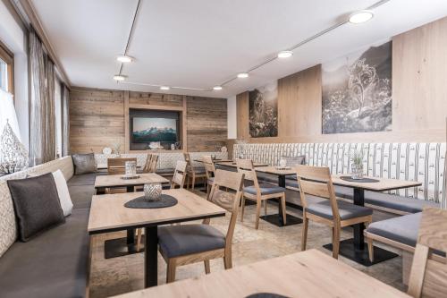 a dining room with wooden tables and chairs at Hotel-Garni Pramstraller in Mayrhofen