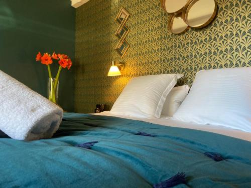 a bedroom with a bed with a vase with orange flowers at LA TOUR YVELINE in Romans-sur-Isère