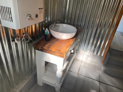a bathroom with a white sink on a wooden counter at Die Ou Pastorie in Fouriesburg