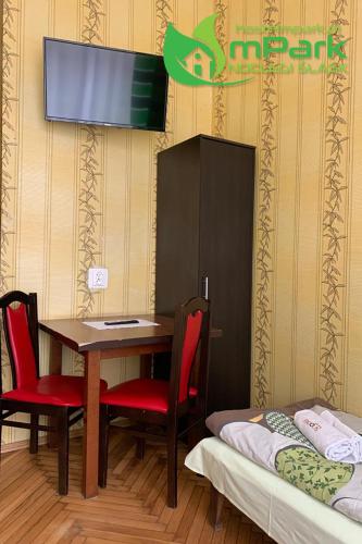 a room with a table and chairs and a tv at mPark Noclegi Śląsk in Chorzów