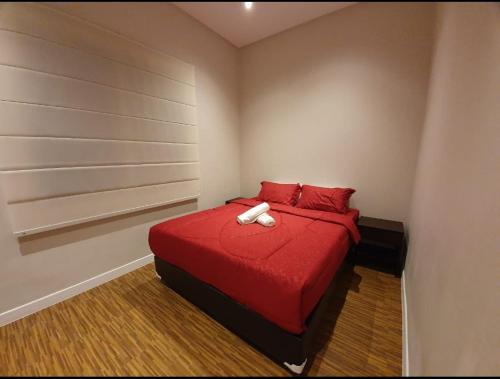 a bedroom with a red bed with red pillows at Puri Mediterania Semarang in Kalibanteng-lor