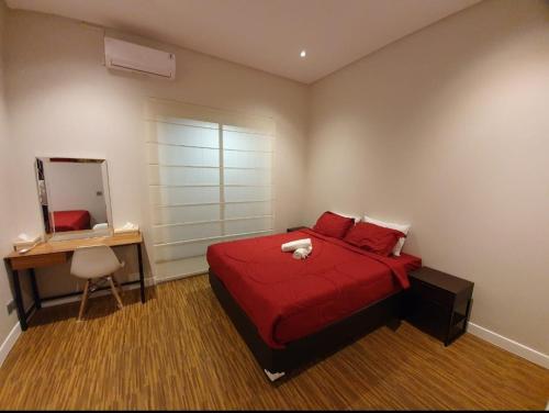 a bedroom with a red bed with a stuffed animal on it at Puri Mediterania Semarang in Kalibanteng-lor