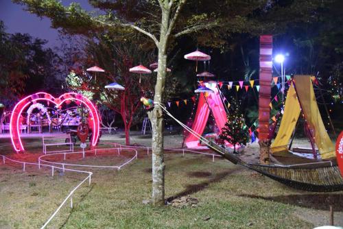 a playground in a park at night with neon lights at ฺBaan Rai Ing Doi in Chaiyaphum