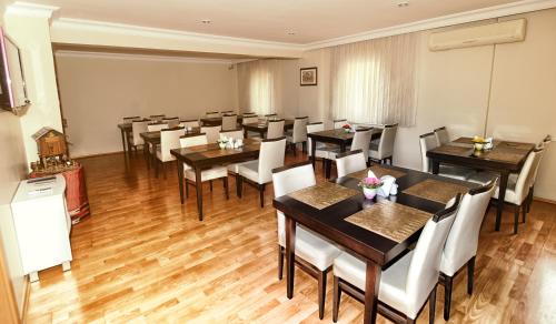 a restaurant with wooden tables and white chairs at Serenti Hotel in Giresun