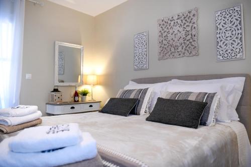 una camera da letto con un grande letto bianco con asciugamani di Vague Summer House a Città di Skiathos