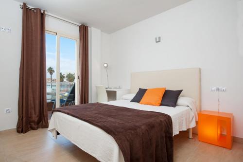 a bedroom with a large bed and a large window at Sunset Lake I in Alcudia
