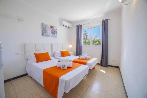a bedroom with two beds and a window at Villa Diana in Port d'Alcudia