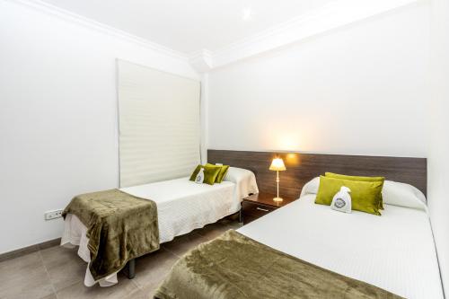 una camera d'albergo con due letti e una lampada di Apartamento Castello Playa a Can Picafort
