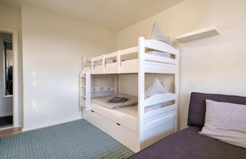 a small room with a bunk bed and a couch at Fördepause in Flensburg
