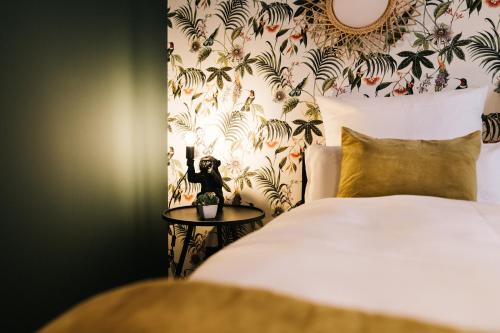 a bedroom with a bed and a wallpaper with plants at Freilich am See - Gästezimmer in Strausberg