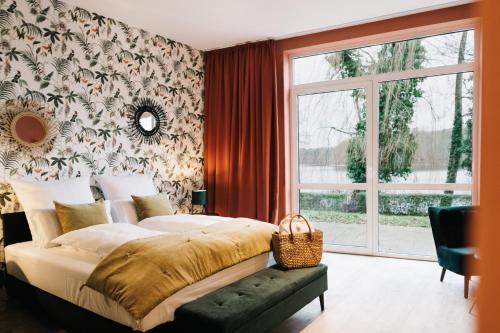 a bedroom with a large bed and a window at Landhaus am See - Gästezimmer in Strausberg