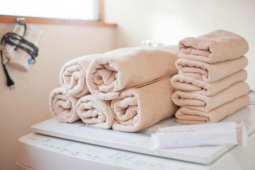 een stapel handdoeken op een plank in een badkamer bij KASUMI-an Hakuzan - Vacation STAY 75321v in Kumamoto