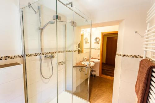 a bathroom with a glass shower and a sink at Landgasthof Hanselewirt in Schwangau