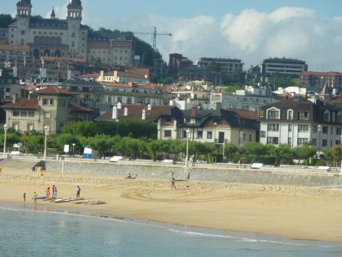 a group of people on a beach near the water at Hotel Ezeiza in Donostia-San Sebastián