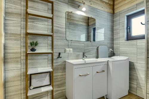 W łazience znajduje się umywalka i lustro. w obiekcie Sielski Spokój Dom z bali Apartamenty całoroczne w mieście Gietrzwałd
