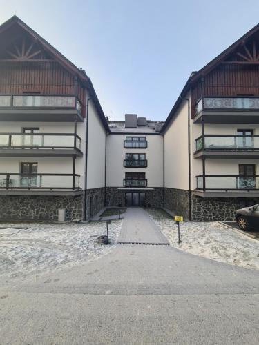 a large white building with two balconies at Apartament Lake View z sauną i widokiem na jezioro in Kluszkowce