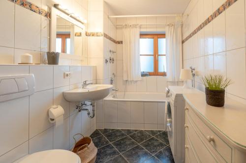 a bathroom with a sink and a toilet and a tub at Hygge in Ofterschwang