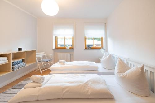 two beds in a room with white walls and windows at Hygge in Ofterschwang