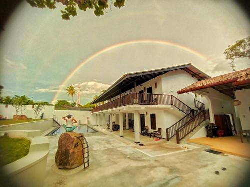 a rainbow in the sky above a house at Ahangama Eco Villa in Ahangama