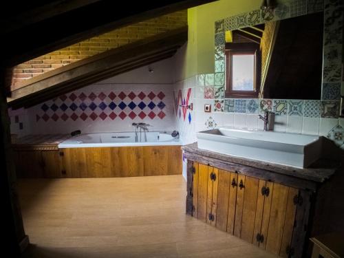 a bathroom with a sink and a bath tub at Posada La Braniza in Vega de Pas