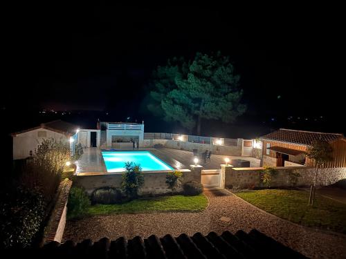 a house with a swimming pool at night at Le Coteau de Bazeille Spa & Sauna in Sainte-Bazeille