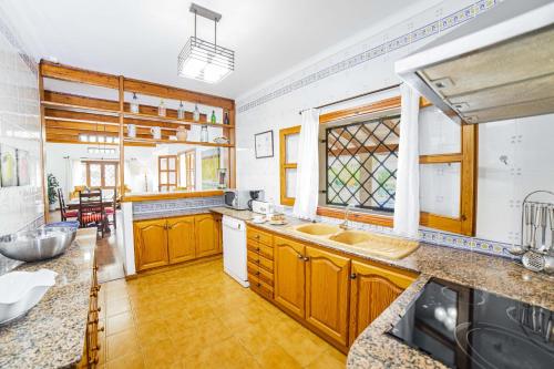 a large kitchen with wooden cabinets and a sink at Villa Ca na Quarta in Alcudia