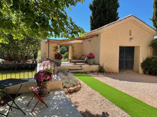 a yard with a house with a bench and grass at Domaine Les Mûriers in Brignoles