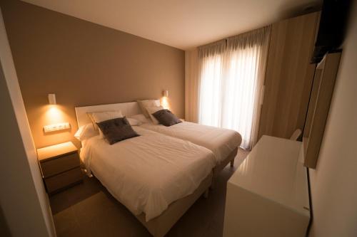 a bedroom with a white bed and a window at Hostal Martínez in Villafranca