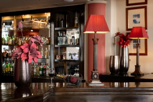 a bar with two lamps and flowers on a counter at Hotel Kierion in Kardítsa