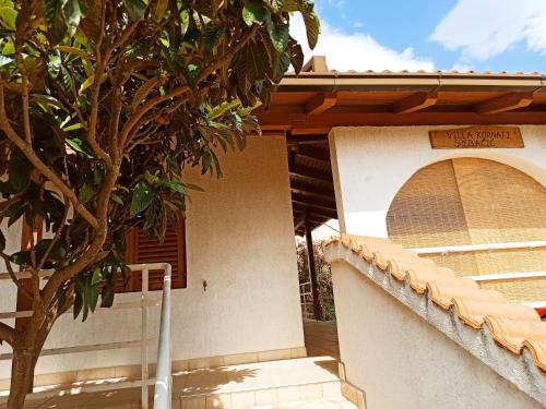 a building with a tree in front of it at Apartments Kornati in Ždrelac