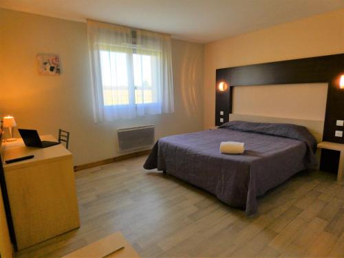 a bedroom with a bed and a desk with a laptop at Hôtel Azur Saint Junien Cit'Hotel in Saint-Junien