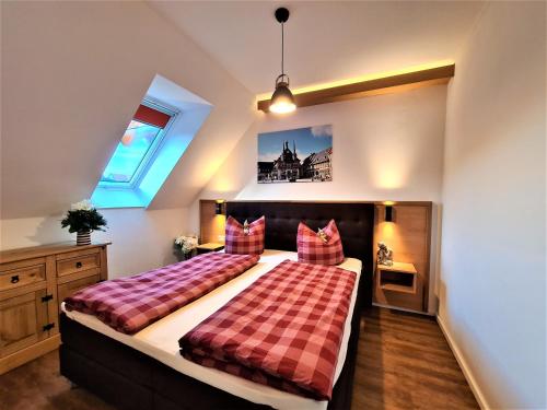 a bedroom with a large bed with a checkered blanket at Ferienwohnungen Burgfried in Wernigerode