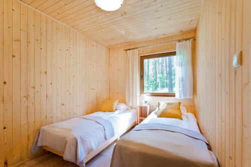 2 camas num quarto de madeira com uma janela em Ośrodek Wypoczynkowy Cubex em Stegna