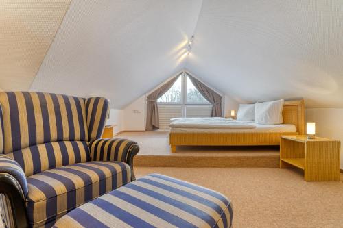 ein Schlafzimmer mit einem Bett, einem Sofa und einem Stuhl in der Unterkunft Ferienhaus am Wäldchen in Norderney