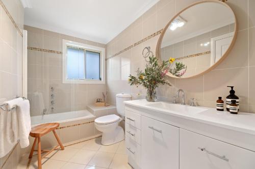 uma casa de banho com um lavatório, WC e um espelho. em Cliff Haven Retreat em Katoomba