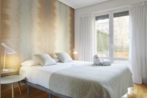 a bedroom with a white bed and a window at Koral - Basque Stay in San Sebastián