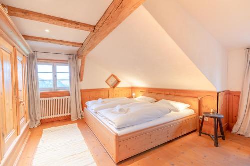 a bedroom with a large bed in a attic at Landhaus Buchenberg in Rettenberg