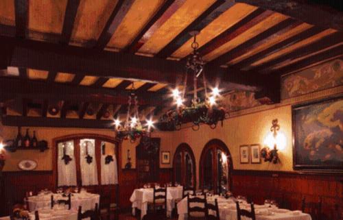 un comedor con mesas blancas y una lámpara de araña en Hotel Arnaldo Aquila D’oro, en Rubiera