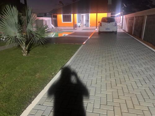 a shadow of a person walking down a street at night at Faith Home 2 in Arraial do Cabo