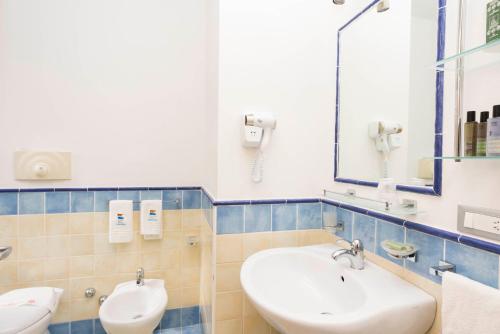 a bathroom with two sinks and a mirror at Hotel Murmann in Maratea