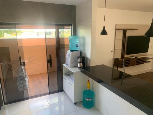 a kitchen with a counter top with a tv and a counter at Faith Home 2 in Arraial do Cabo