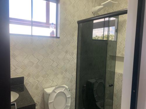 a bathroom with a toilet and a shower at Faith Home 2 in Arraial do Cabo