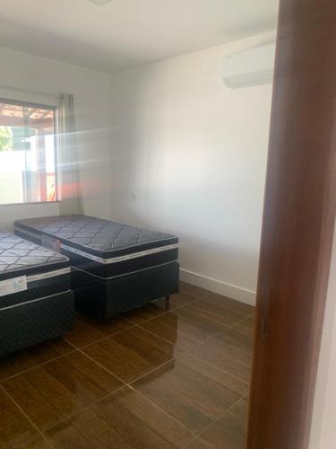 two twin beds in a room with a mirror at Faith Home 2 in Arraial do Cabo