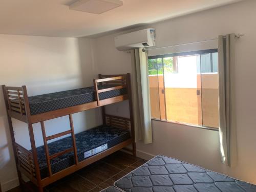 two bunk beds in a room with a window at Faith Home 2 in Arraial do Cabo