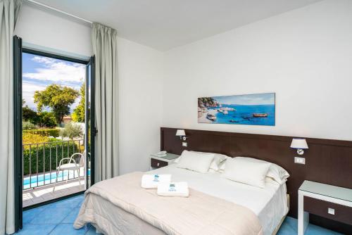a hotel room with two beds and a balcony at Hotel Murmann in Maratea