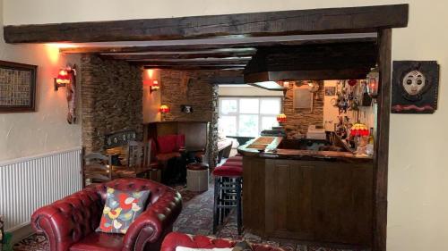 a living room with a red couch and a bar at The Poplars Guest House in Combe Martin