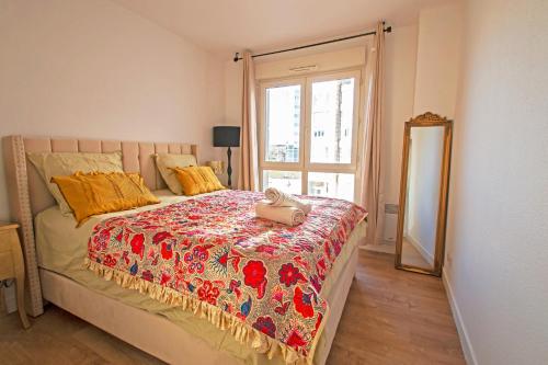 een slaapkamer met een bed, een spiegel en een raam bij Appartement Cosy , Vue imprenable, Parking Privé in Montpellier