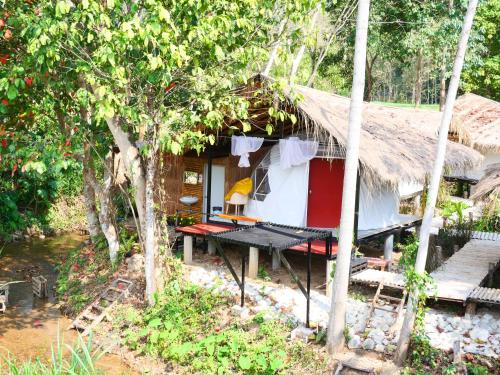 a house with a thatched roof and a picnic table outside at Nansilarom in Ban Bun Yun